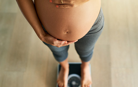 Schwangere Frau, die ihren Bauch umarmt