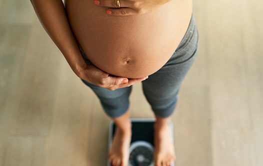 Schwangere Frau, die ihren Bauch umarmt