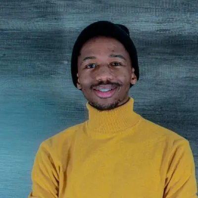 The portrait photo of Luthando Allistair Vilakazi wearing a yellow turtleneck.