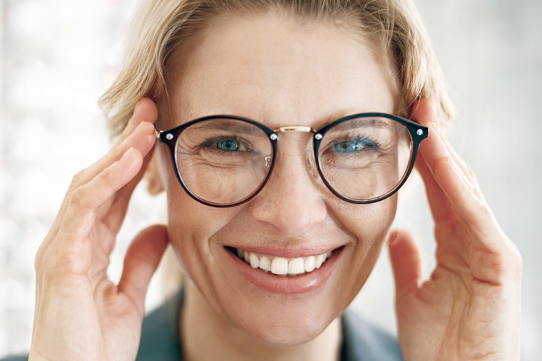 Woman trying on a pair of eyeglasses.