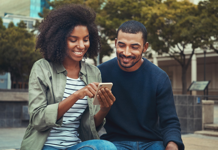 Young couple after LASIK smiling at phone