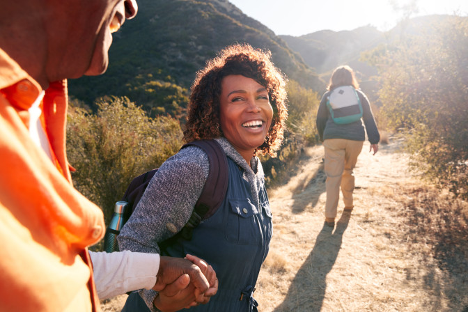 Woman experiencing joy of sight after LASIK eye surgery during hike holding hands happy smiling