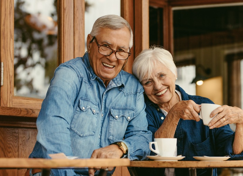 Older age-related macular degeneration couple drinking coffee looking at camera 