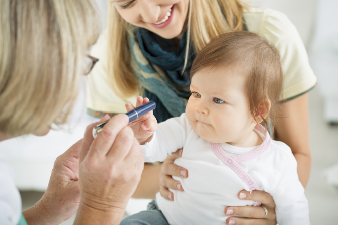 Infant child during pediatric eye exam with expert eye doctor