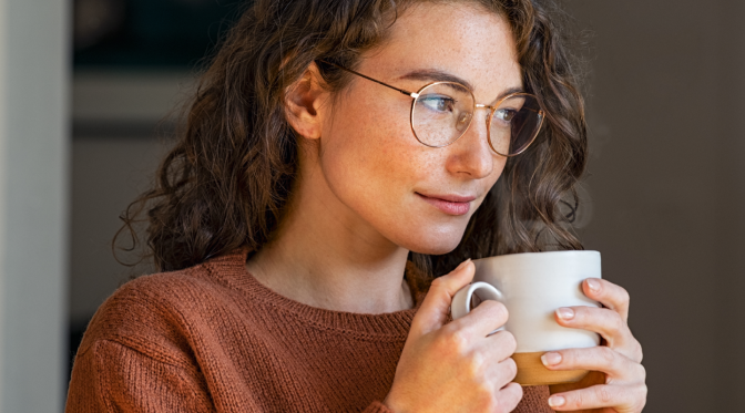 Girl holding coffee wearing prescription glasses trendy smiling