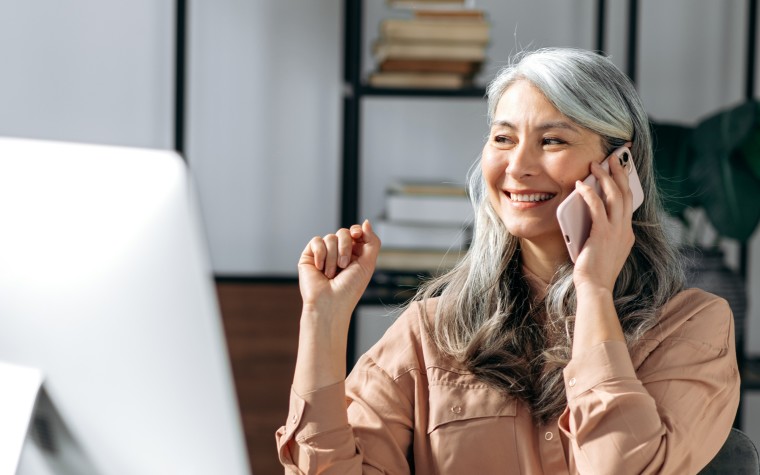 Smiling woman cataract patient on phone checking vision insurance benefits