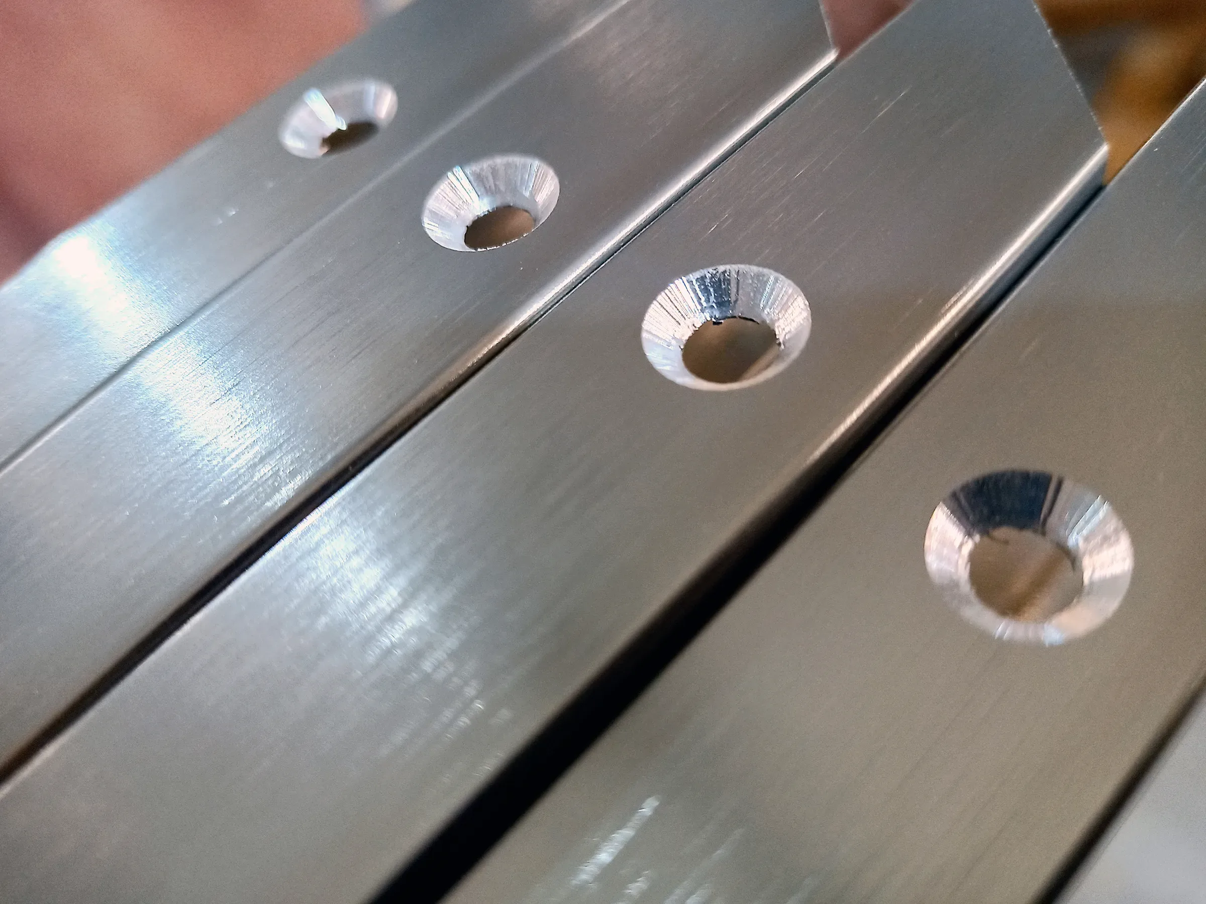 A hole in the aluminum metal made with chamfer or countersink on aluminum profile