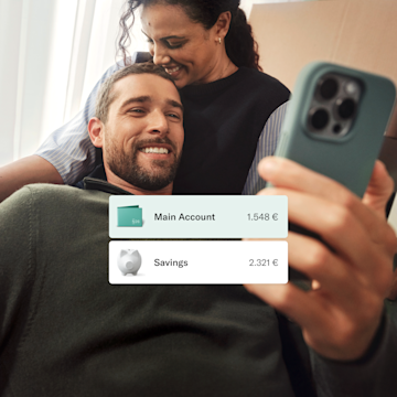 A couple is sitting on the couch, the man is looking at his phone.