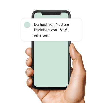 Hand mit einem Handy, auf dem eine Ratenzahlungsbenachrichtigung angezeigt wird.