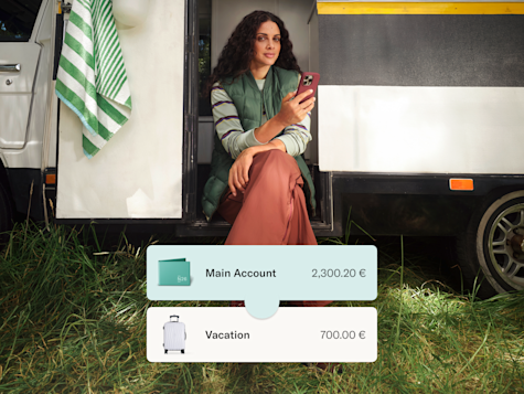 A woman sits in a campervan doorway with overlaid cards showing her main bank account and vacation savings balances.