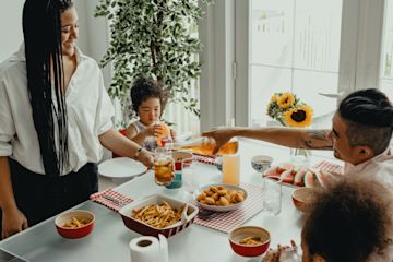 Una familia comiendo en la mesa.