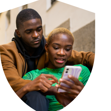 Image of a man hugging a woman while she looks at the mobile.