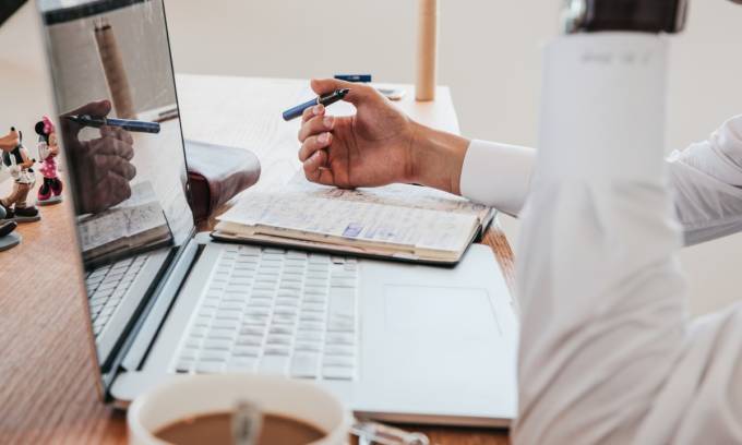 Ein Freelancer, der am Laptop arbeitet und einen Kaffee trinkt.