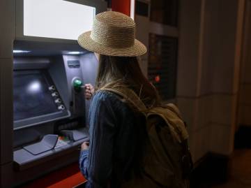 femme retirer de l'argent à un guichet automatique.