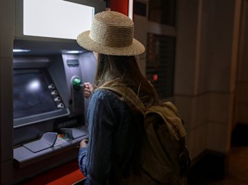 femme retirer de l'argent à un guichet automatique.