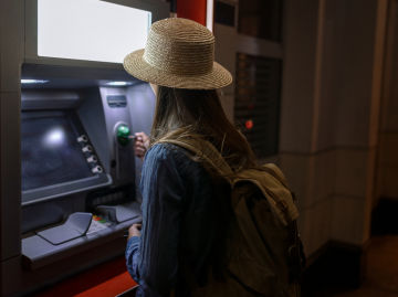 Mujer retirando dinero en un cajero automático.