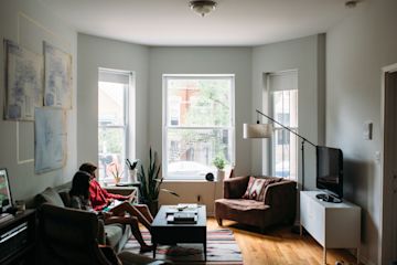 Roommates sitting on couch in living room.