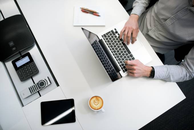 Person working on a laptop at the desk.