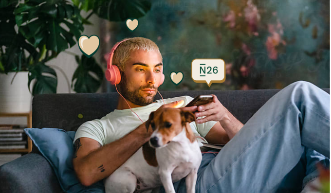 A man checking his smartphone on the sofa along with his dog.