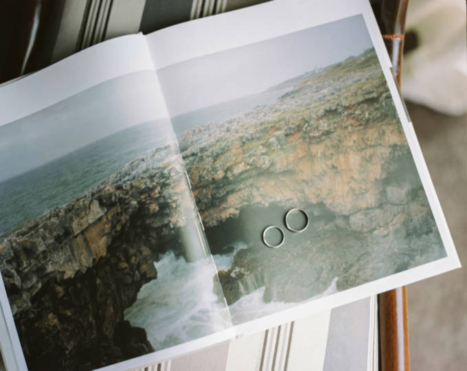 book open with a nice picture of a cliff and with two wedding rings over the picture.