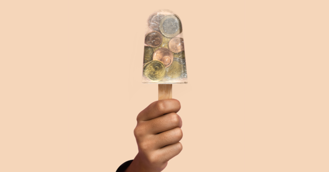 Hand with an ice cream showing coins inside the ice cream as if the ice cream were transparent.