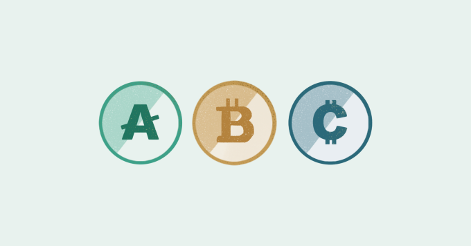 Drei verschiedene Krypto-Coins auf einem Tisch.