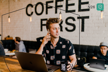 Man in a coffee shop working on his laptop.