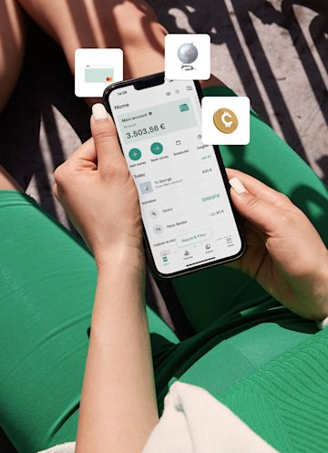 Person in green suit sitting and holding mobile phone with n26 application.