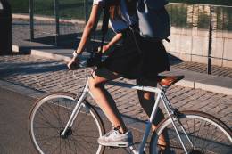 Woman with backpack rides a bike.