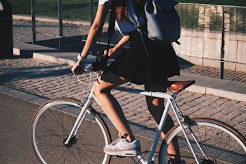 Woman with backpack rides a bike.