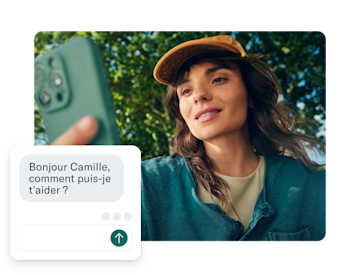 Une femme tient son téléphone vers l'appareil photo, avec une boîte de discussion de service client superposée à l'écran.