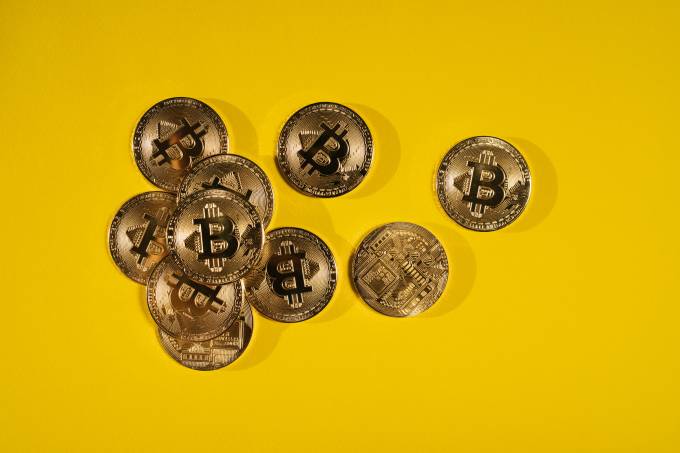 Bitcoin-Münzen auf einem gelben Hintergrund.