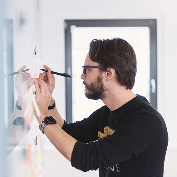 Man writing on a whiteboard.