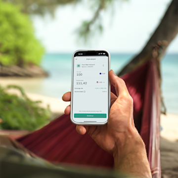 Hand holding a mobile showing an international bank transfer in the N26 app. 