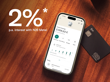 A smartphone displays the N26 Instant Savings screen next to a black N26 Metal Mastercard.