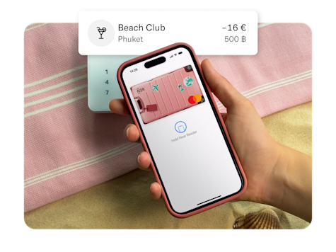 A hand holding a mobile phone displaying a virtual card with a luggage design.