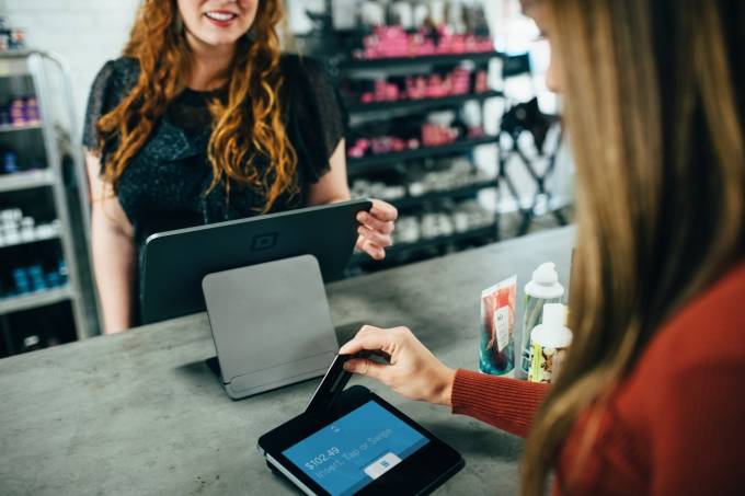 Woman paying with a contactless card in a store.