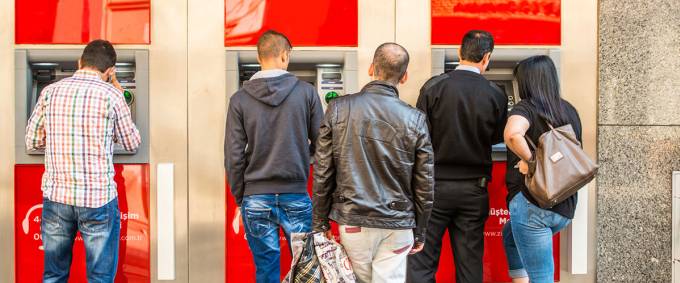 People waiting at an ATM.