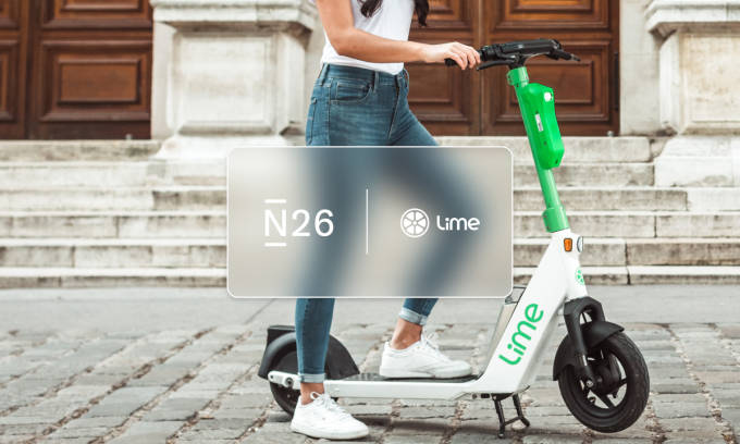 La tarjeta N26, la aplicación y la persona que conduce un scooter eléctrico.