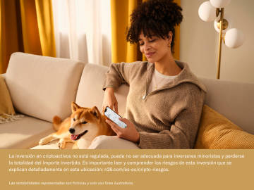Mujer sentada en un sofá mirando la aplicación N26 con su perro.