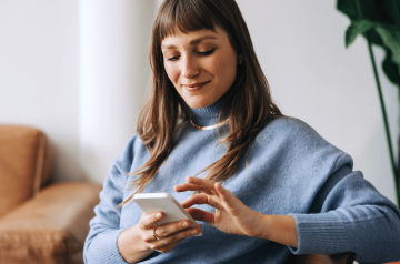 Image d'une femme regardant ce que sont les options d'achat d'actions sur son smartphone.