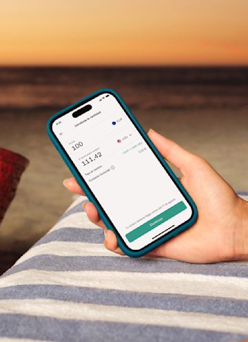Mano sosteniendo un móvil que muestra una transferencia bancaria internacional en la app de N26.