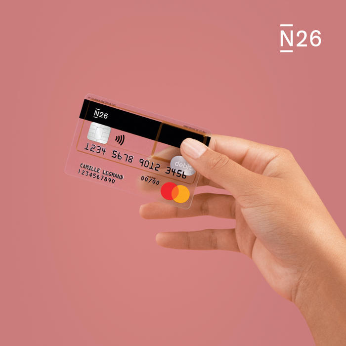 Hand hält eine transparente Debitkarte von N26.