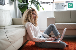 Woman works on laptop on the floor. 