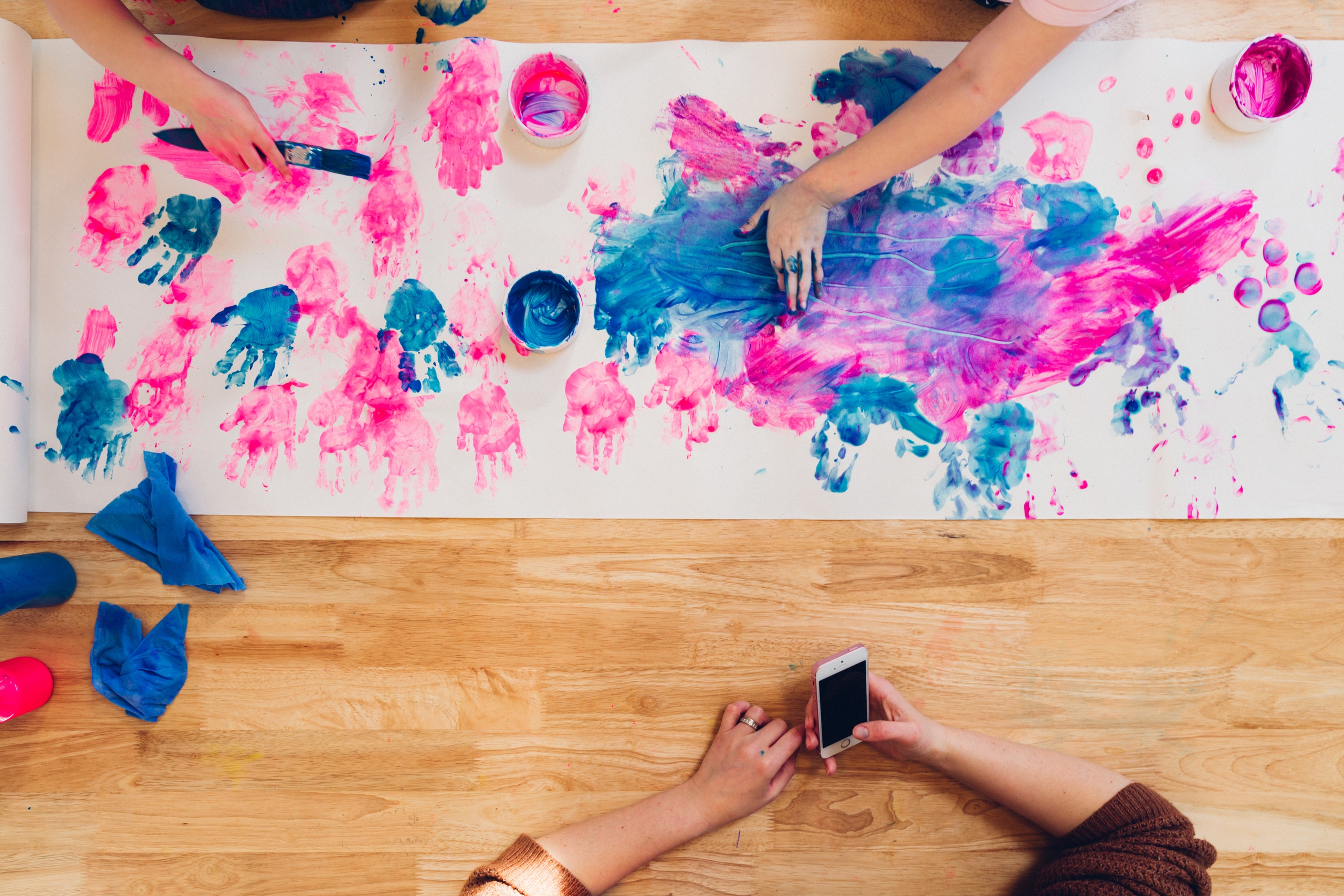 Kids painting on a white paper.