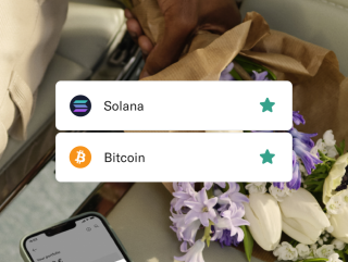 Tether and Bitcoin crypto coins and some flowers in the background.