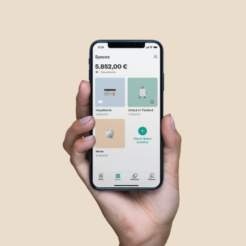 Hand hält ein Handy mit N26-App-Funktion Spaces.