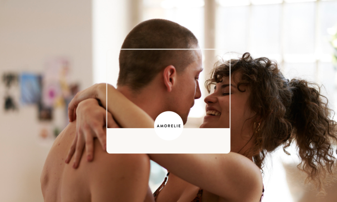 Two people embracing with the Amorelie logo at the front.
