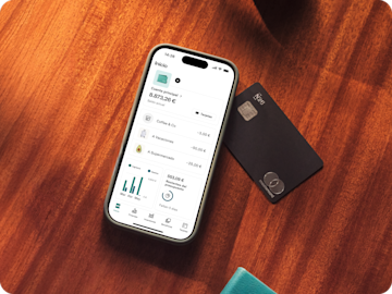 Un smartphone muestra la pantalla de inicio de la aplicación bancaria N26 junto a una Mastercard N26 negra.