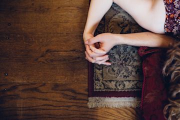 Couple holding hands on a rug.